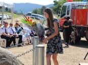 Poignant: Megan McPaul puts flowers at the memorial rock that honours her husband Samuel.