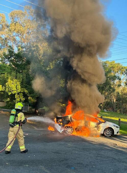 Giving it a blast: A firefighter directs his hose on to the Mazda which was left a wreck after being stolen and dumped in Albury on Sunday.