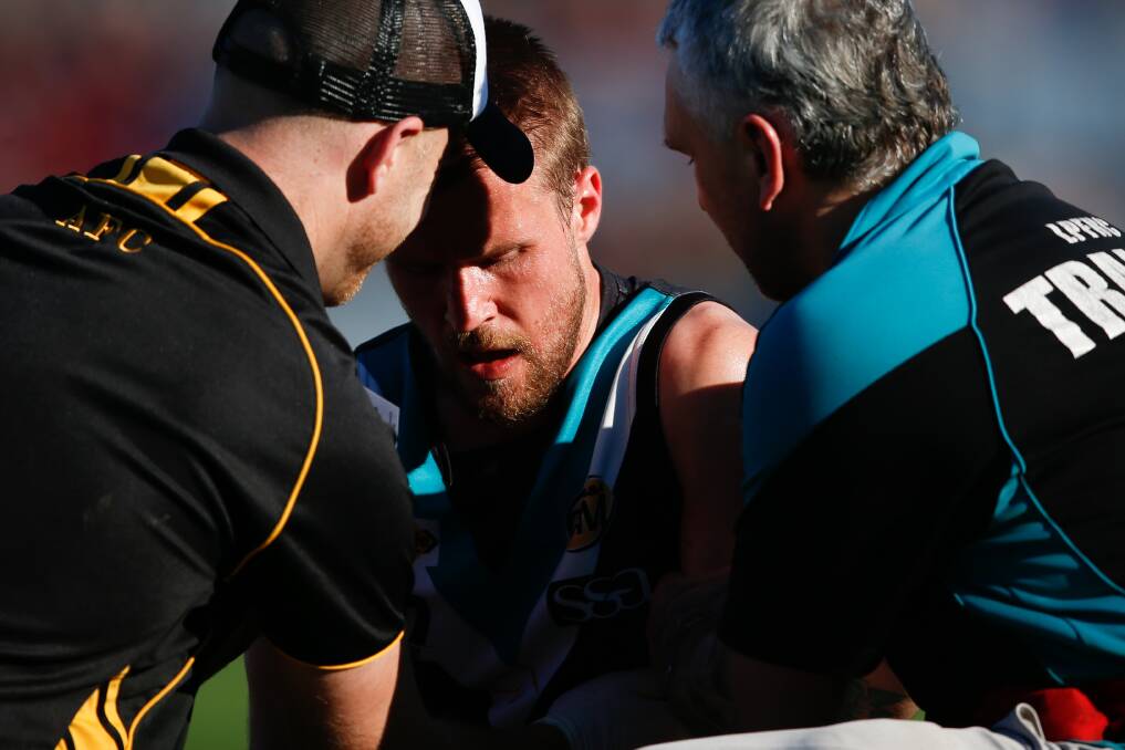 Mitch Palmer is helped off by trainers from both teams during the 2015 grand final between Lavington and Albury.