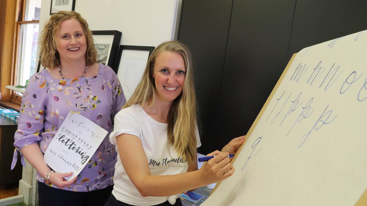 TRYING SOMETHING NEW: Alison Joshua learns about the art of brush lettering from teacher Kate Bower. Picture: Les Smith