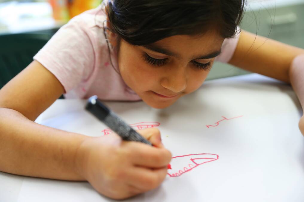WORKING HARD: Soso Hasan, 6, concentrates as she draws out the design she wants to see on paper. Picture: Emma Hillier 