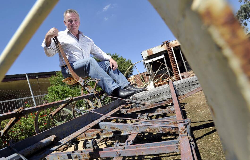 PRACTICAL SOLUTIONS: Manager of the Museum Luke Grealy sits on a vintage cropping machine, one of the many items the site is home to. Picture: Les Smith 