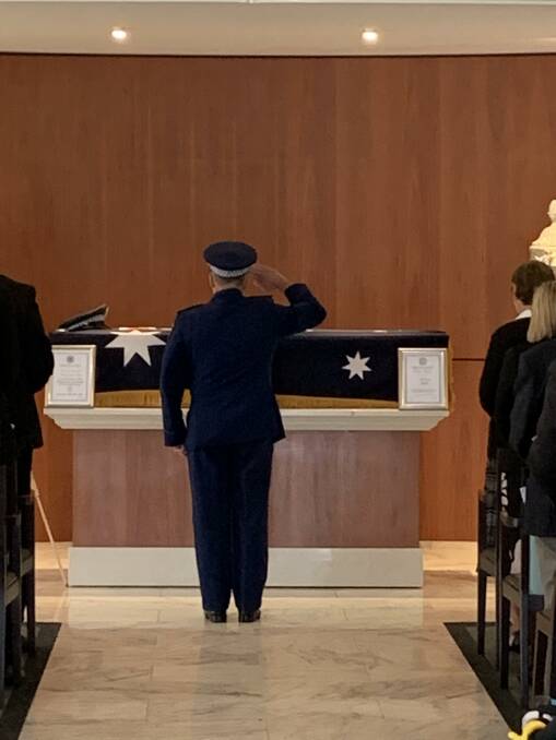 THANK YOU FOR YOUR SERVICE: Acting Detective Inspector Phil Malligan salutes after placing a police hat on the casket.