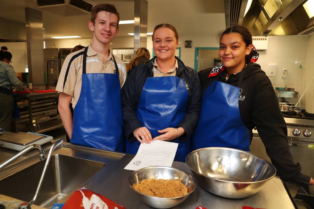 FUN IN THE KITCHEN: Kooringal High students Zac Taylor, 16, Eden Absolum, 16 and Halle Maiukaetau, 16, help prepare meals.