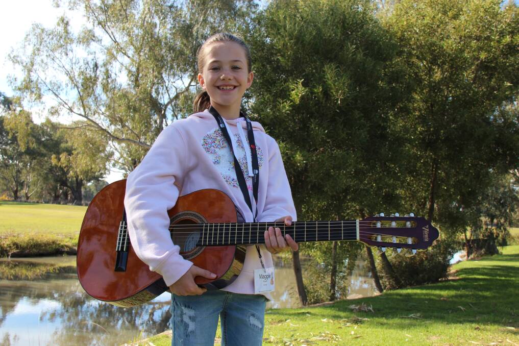 GUITAR HERO: Maggie Roache, 9, is geared to perfect her skills on the guitar at the week-long camp. Picture: Jennifer Gollasch 