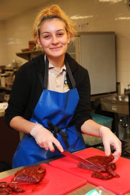 LEARNING NEW SKILLS: Diana Stojanovic, 16, learns how to prepare food that will go to Carevan Wagga. Picture: Emma Hillier 