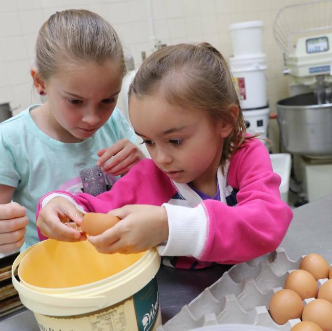 IN 2017: Jordan McFadden, 8, and her sister Laura, 4, develop their expertise at cracking eggs. Picture: Les Smith 