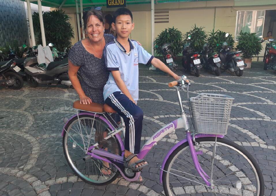 SAFE RIDING: Kelli with one of the children she bought a bicycle for so he could ride to school. 