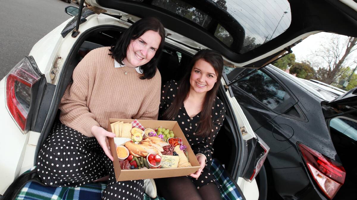 MOVIE TREATS: Emma Corbett and Kim Parker prepare their car for a drive-in movie experience. Picture: Les Smith