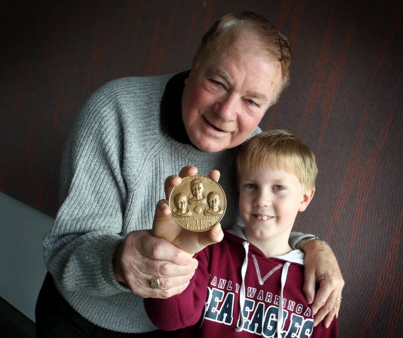 REMINISCING: Wagga's Dennis Blackett showing his grandson Austin a medallion commemorating the moon landing. Picture: Les Smith