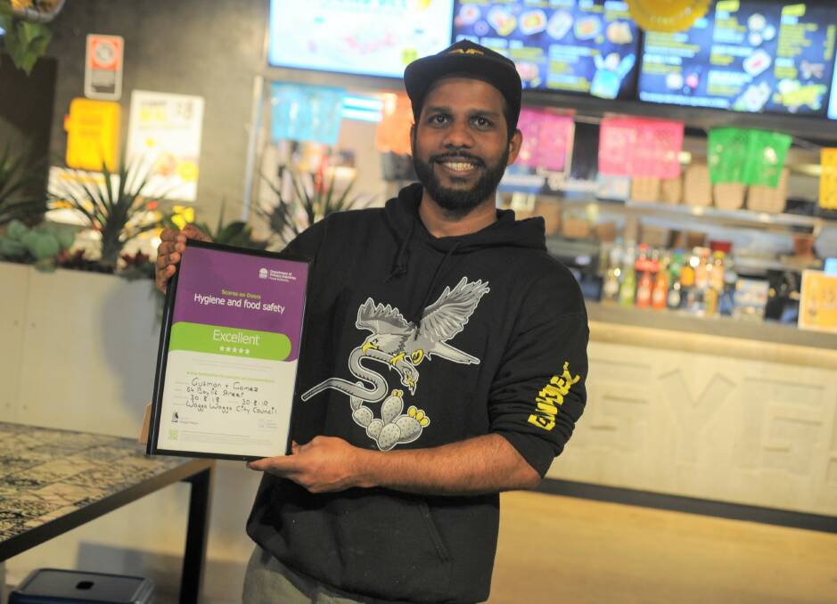 HIGH STANDARDS: Guzman y Gomez restaurant manager Ahmed Mustafa showing the 5-star rating certificate they earned through the Scores on Doors initiative. Picture: Daina Oliver