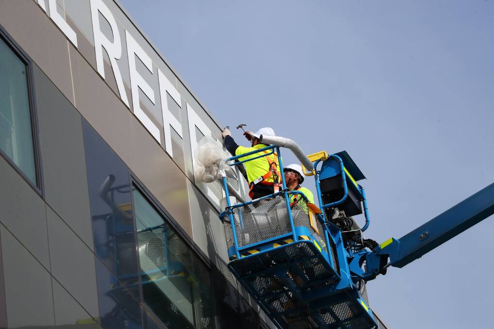 COMING DOWN: Workers use a 45-metre ultra-boom lift to remove the Wagga Rural Referral Hospital from the fifth-floor exterior of the hospital's main building. Picture: Emma Hillier