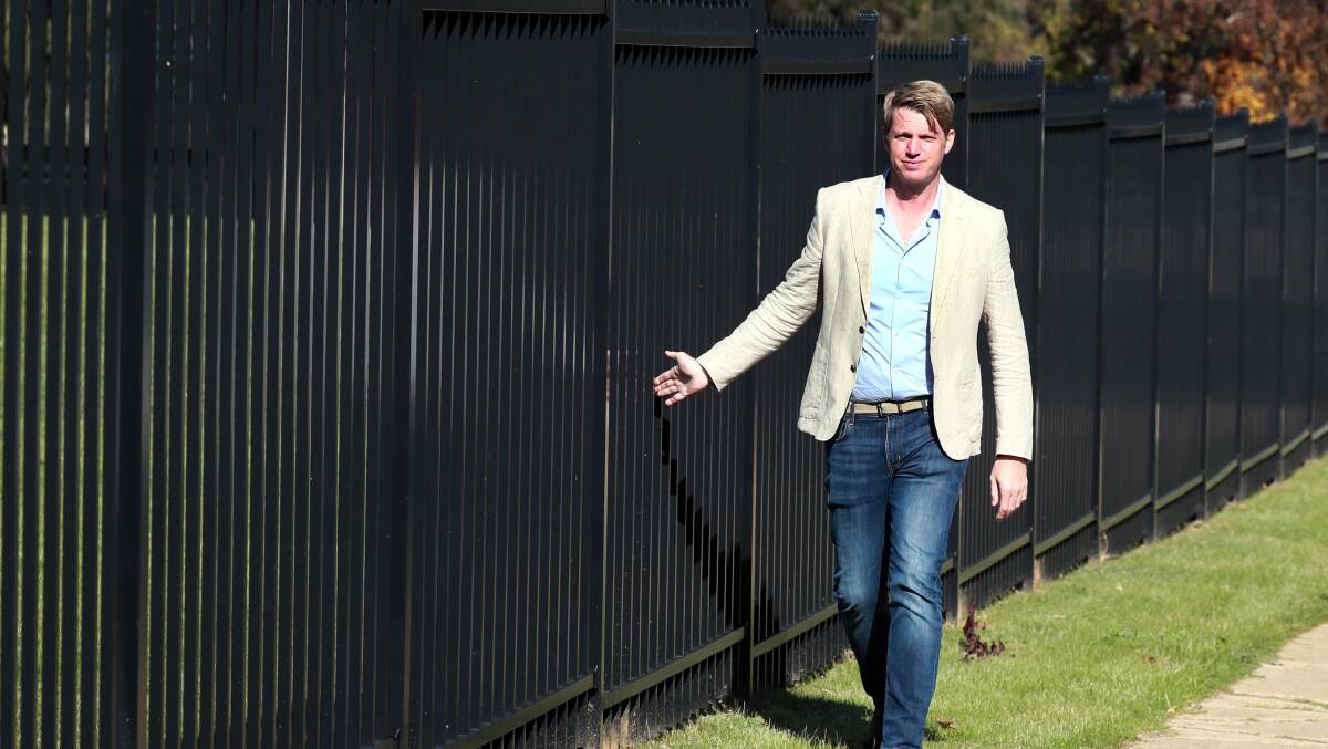 BEHIND BARS: Wagga councillor Dan Hayes outside a fenced off school oval that was once open for public use. Picture: Les Smith 