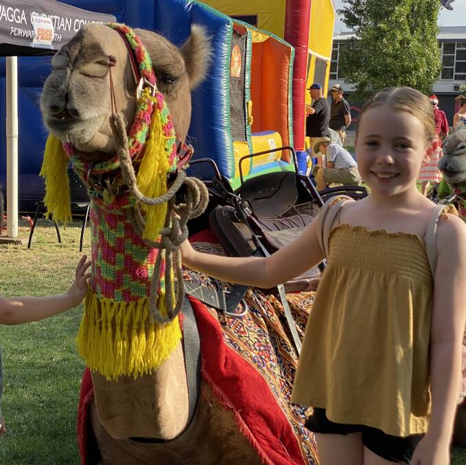 Ayla Byrne, 9, patting the camels at the Christmas Carols in the Park.