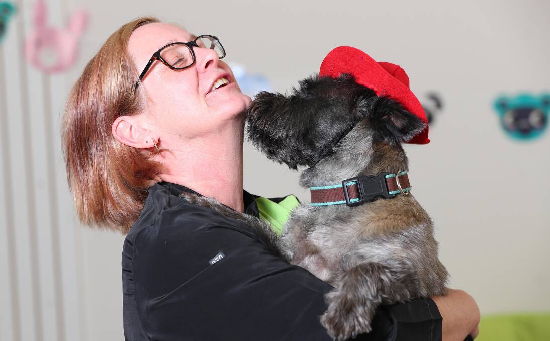 KEEPING COOL: Julie Seymour from TLC Grooming and Doggie Daycare gets a friendly greeting from George. Picture: Kieren L Tilly