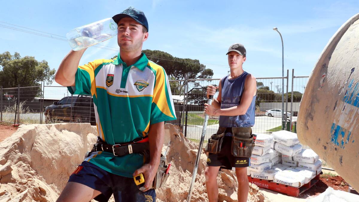 KEEPING IT COOL: Apprentice builders Harry Fitzsimmons, left, and Charlie Spackman are bracing themselves for the expected high temperature across the region tomorrow. Picture: Les Smith