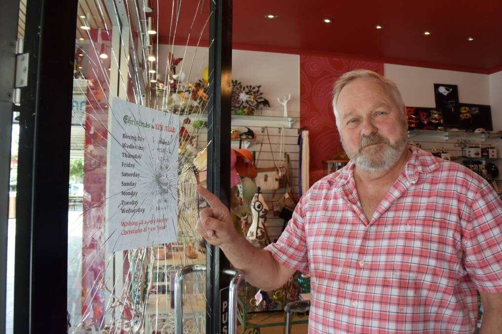 Wagga retailer Tony Carlin and the smashed door of his Baylis Street store. Picture: Jody Lindbeck