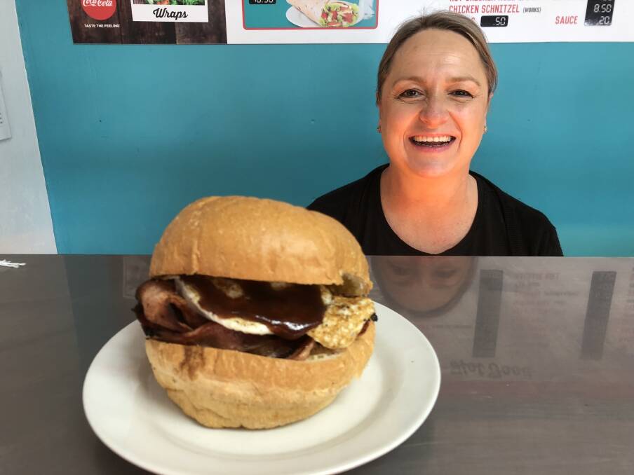 HELPING OUT: Lisa Bloomfield of Westside Sandwich Shop with a big egg and bacon roll. Picture: Jody Lindbeck