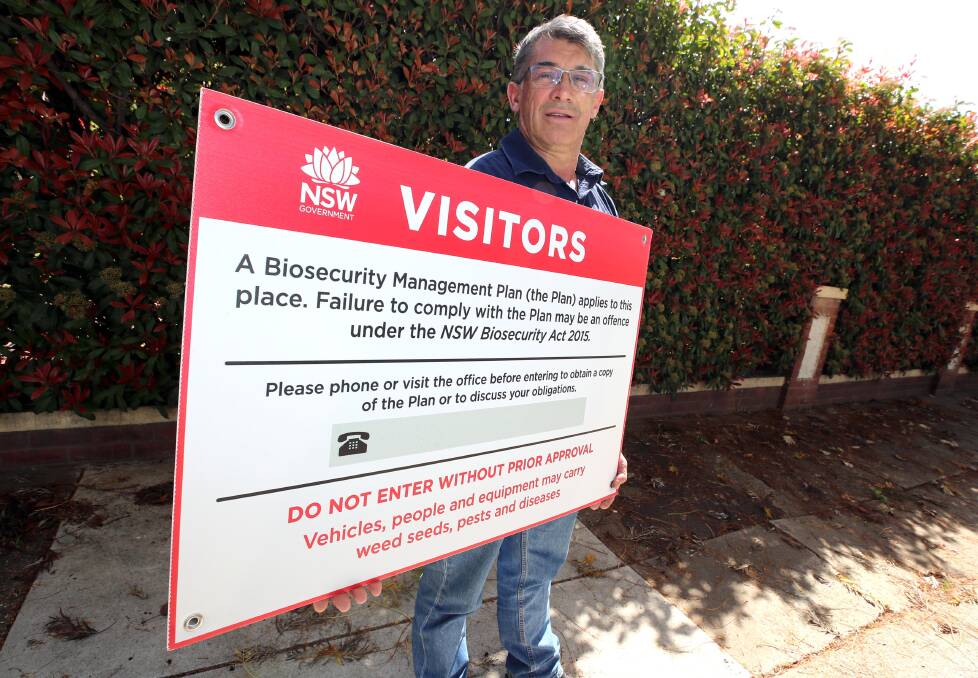 SIGN OF THE TIMES: Riverina Local Land Services' manager of biosecurity and emergency services Michael Leane with one of the signs. Picture: Les Smith