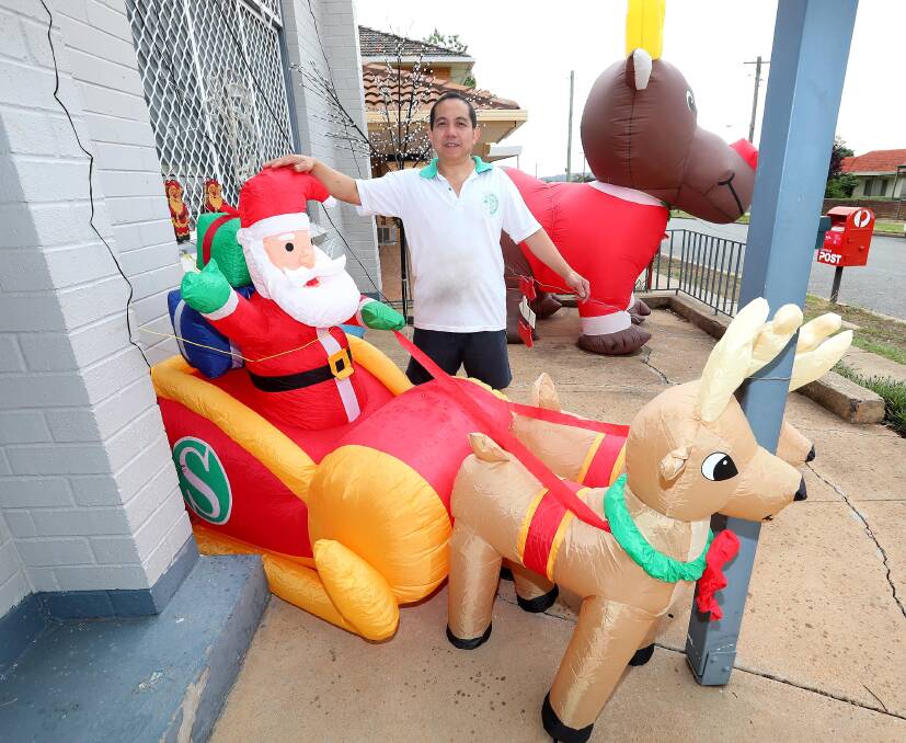 CHRISTMAS CRACKER: Tommy Sauw outside his Ceduna Street cafe, which is decked out for Christmas. Picture: Kieren L Tilly