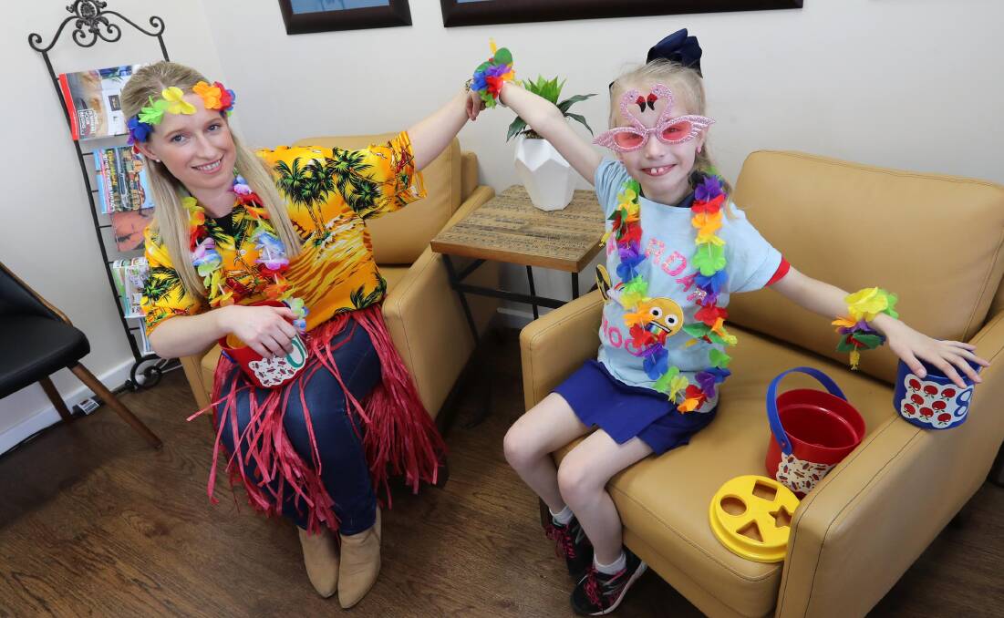 HELPING HAND: Teresa Redway and her daughter Isabella take a break during a fundraiser held at the Wagga office of RSM, where Mrs Redway works. Picture: Les Smith