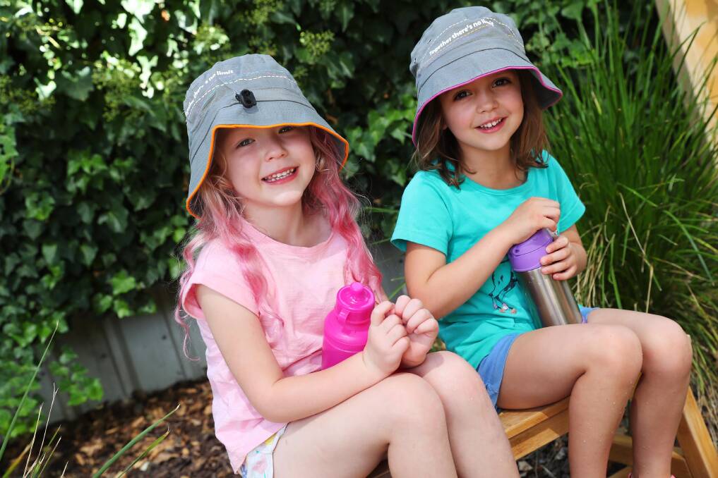 HOT WEATHER: Chloe Burman and Grace Gilholme, both aged four, have their hats and water bottles at the ready as they find a spot in the shade to stay cool. Picture: Emma Hillier