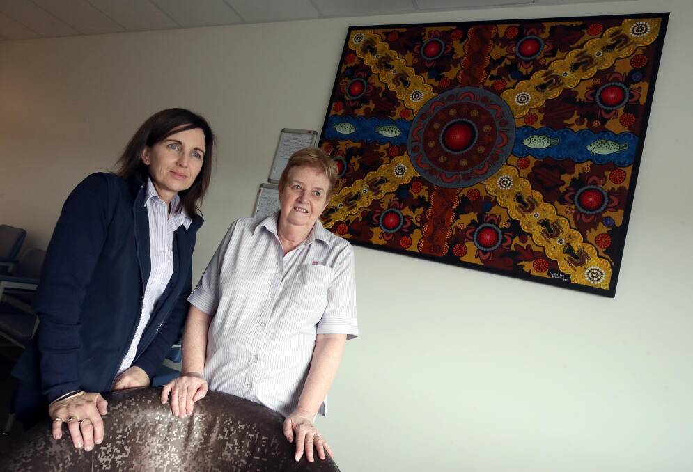 ART SPACE: Wagga Base Hospital administration officers Gerri Duncombe (seated) and Kathy Ogden admire a work by artist Fay Clayton, a Wiradjuri woman. Picture: Les Smith
