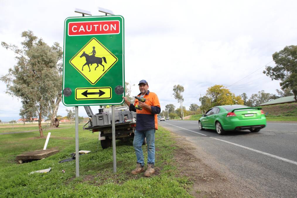 Geoff Levkich from High Country Communications puts the finishing touches on the new solar-powered warning lights in Travers Street.