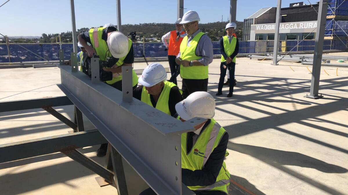A beam on the new ambulatory care building will be forever adorned with messages from construction workers, NSW Health staff and official visitors from the "topping out" ceremony.