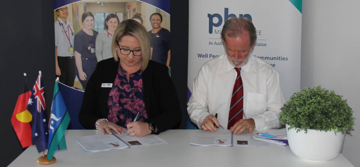 Murrumbidgee Primary Health Network chief executive officer Melissa Neal and Murrumbidgee Local Health District acting chief executive, Maurice Ahern sign the Murrumbidgee maternal and child health strategy.