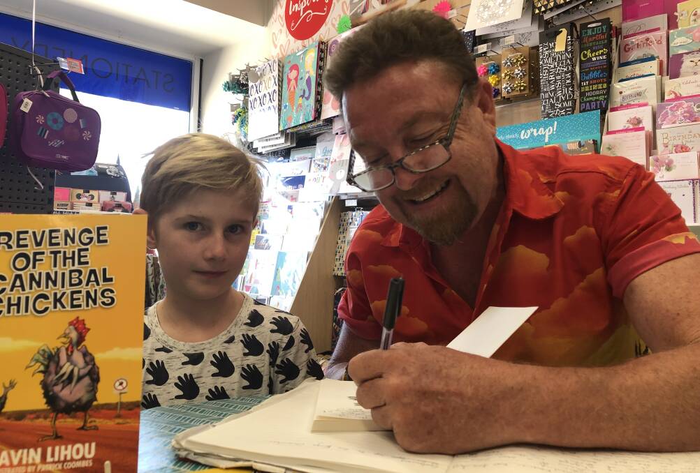 SIGNED UP: Wagga teacher and author Gavin Lihou signs a copy of his children's novel Revenge of the Cannibal Chickens for Harvey Douglas, 9, at Turvey Tops newsagency.