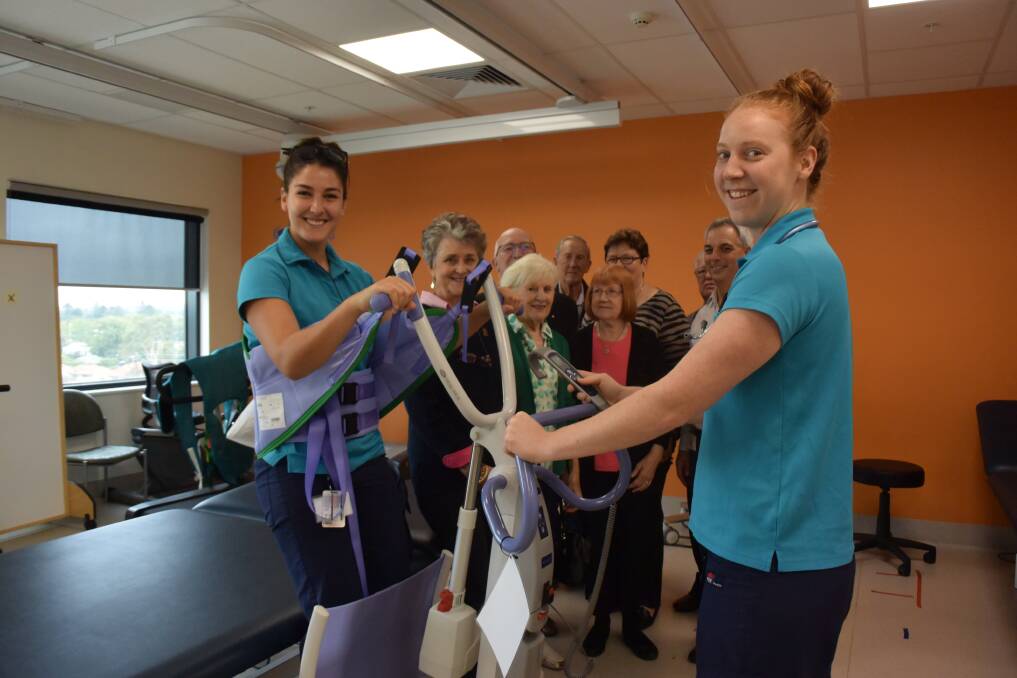 Wagga Base Hospital physiotherapists Giulia Casson and Charlotte Lymbery demonstrate a piece of equipment designed to help safely move patients.
