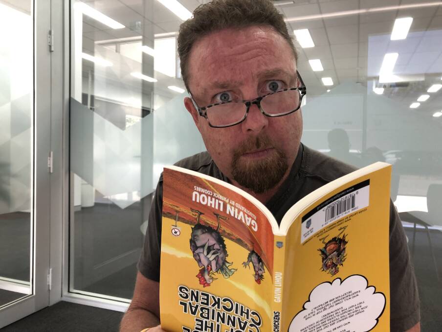 LIGHT MOMENT: Wagga teacher and author Gavin Lihou has a laugh with a copy of his book, Revenge of the Cannibal Chickens. Pictures: Jody Lindbeck