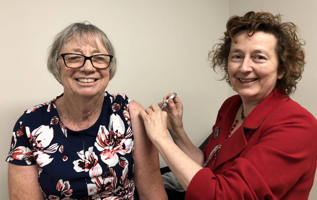 Gayle Murphy, chair of the Murrumbidgee Health District board, receives a flu shot from Wendy Cox, the executive director of medical services