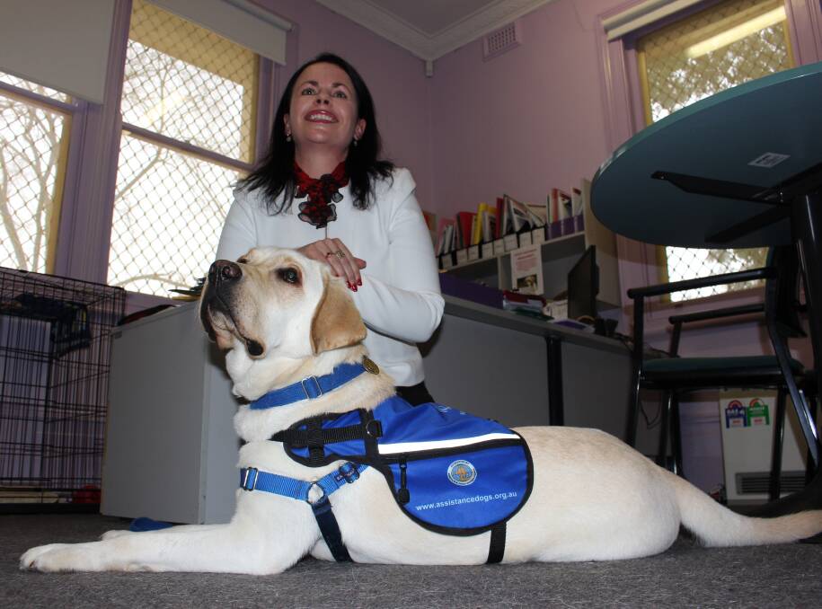 CANINE CELEBRATION: The Bidgee School president Marianne Mitchell and 2-year-old trained labrador Humphrey await his official commissioning on Tuesday. 