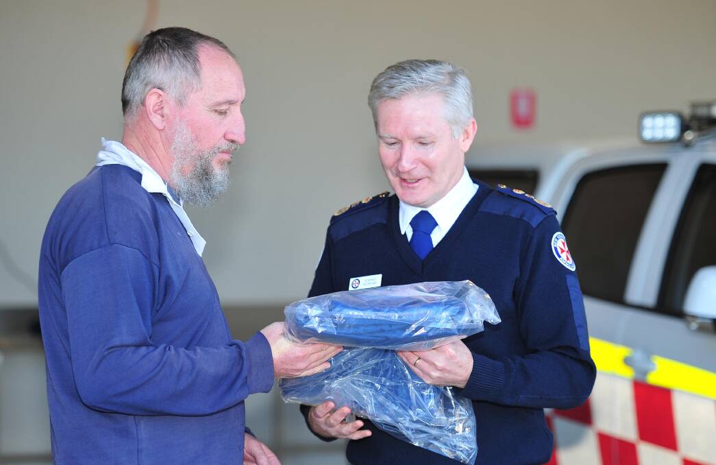 Volunteer Martin Steele from Coolamon accepts his uniform from NSW Ambulance commissioner Dominic Morgan.