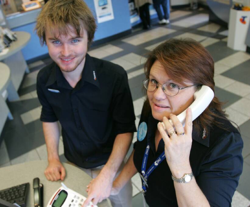 NO USAGE: Telstra shop workers Jordan Stewart and Jacie Cockburn with a landline phone, which is less and less being used by residents. 