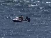 A passerby rescues a fallen jet ski rider near Windang Island, as seen in this still from footage taken by Jess Baird.