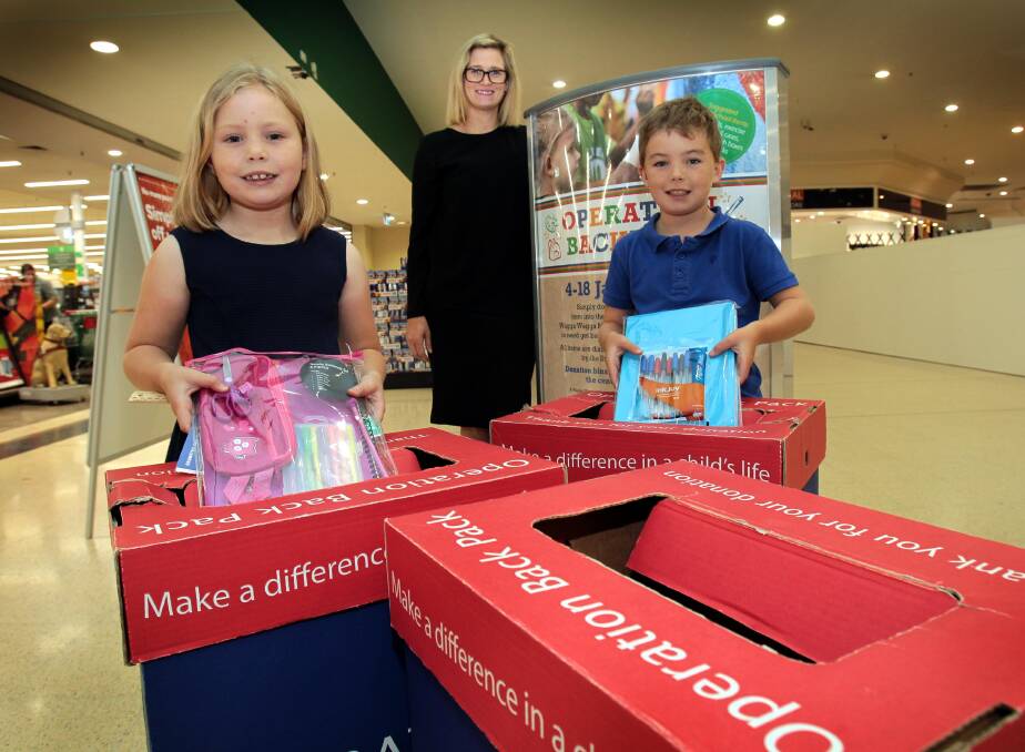 Generous: Ariah Park kids Georgia Pursehouse, 6, and her brother Angus, 7 donate to Operation Backpack while Wagga Marketplace marketing co-ordinataor Sheridan Ingold looks on. Picture: Les Smith.