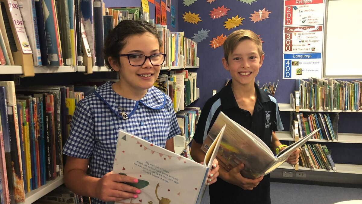 MOVING FORWARD: Wagga Public's school captains Cleo Campbell, 11, and Harry Austin, 11, are among donated books following the fire. 