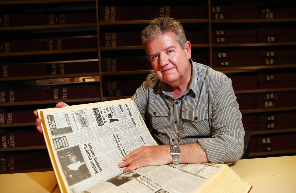 GROUND ZERO: Les Smith flicks through old archived copies of newspapers of pictures depicting forensics carrying out one of the first bodies found in 1992. Picture: Emma Hillier