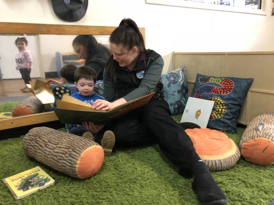 BOOK TIME: Education leader at Ashmont's Goodstart Early Learning is reading a children's picture book with Jonathon Haines, 22 months. Picture: Jess Whitty 