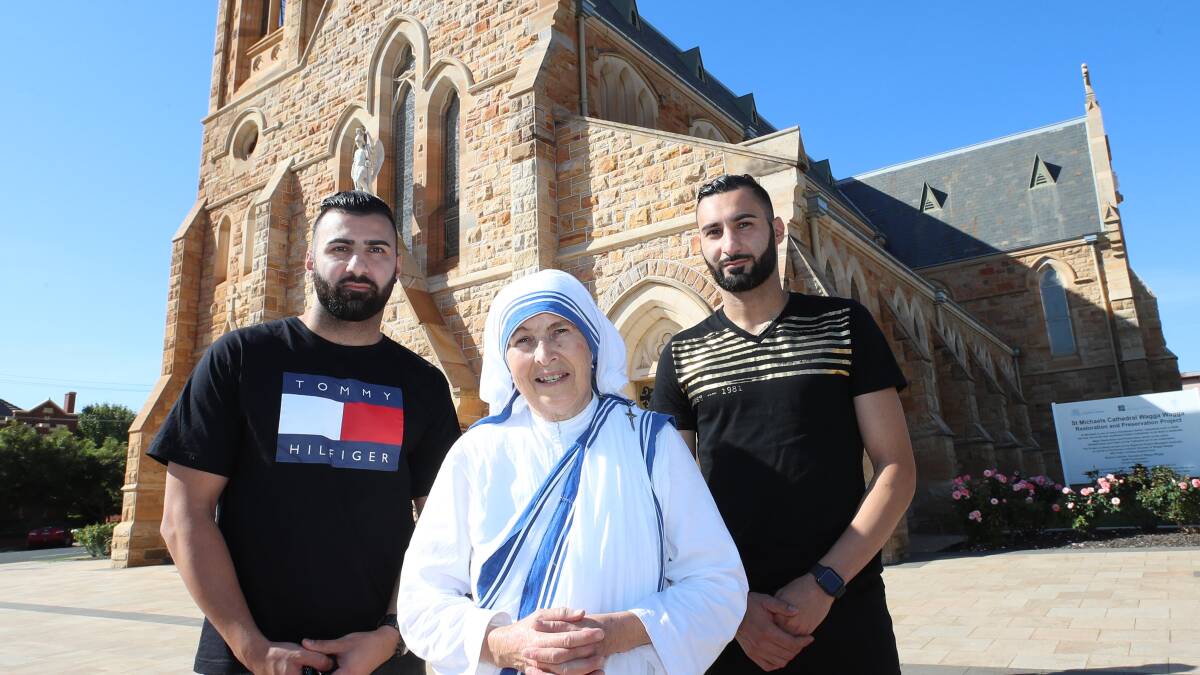 REFLECTION: Twin brothers and local soccer stars Fred and Henri Gardner with Sister Hannah from the Missionaries of Charity at Saint Michael's Cathedral. Picture: Les Smith

