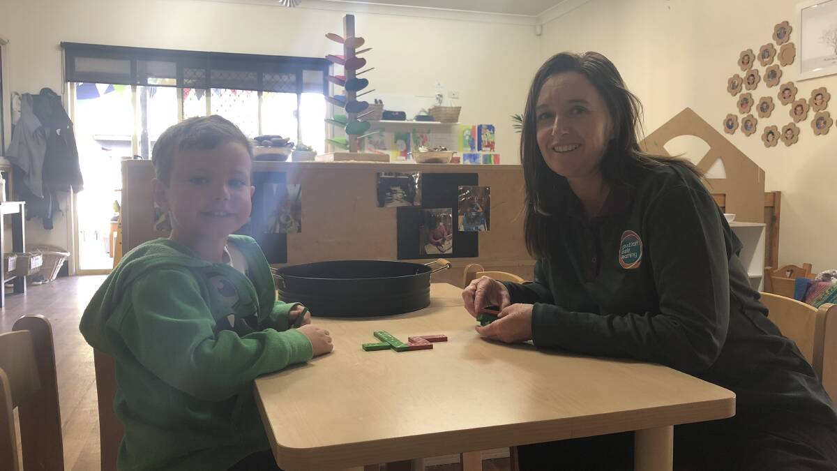 DOMINO: Oliver Shepherd, 5, with his early childhood teacher Vivienne Guy, is learning mathematical skills in dominoes through play-based learning. Picture: Jess Whitty