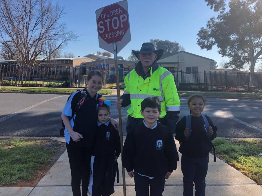 READY FOR SCHOOL: Shakilah-Jayne Mathers, 12, Uneike Valma-Ann Mathers, 5, Sam Fogarty, 6, lollipop man Bernie Hinchcliffe and Emily Thomas, 6, are ready to cross the road. 