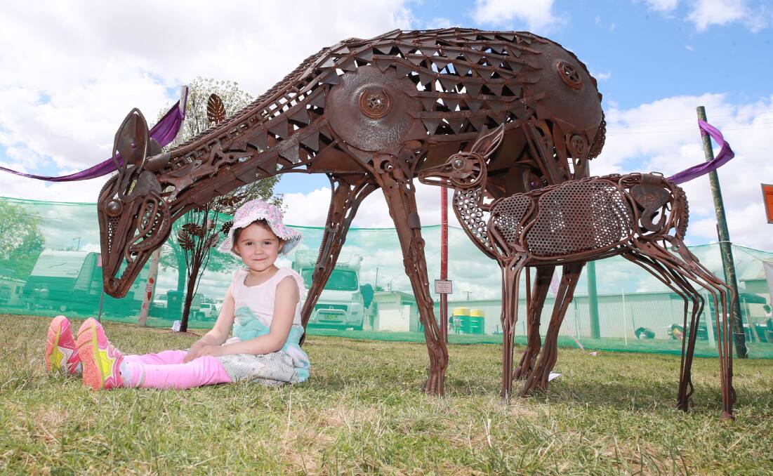 FAVOURITE: Narrandera's Scarlett Light, 5, sits in front of her favourite art display: Peter Colby's Doe with Fawn at Foot. Picture: Les Smith