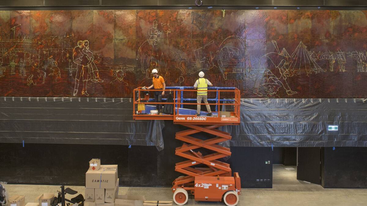 MONUMENTAL TASK: Workers install Sidney Nolan's huge Eureka Stockade mural at the ANU's new cultural centre after it was donated by the Reserve Bank of Australia. Picture: Lannon Harley