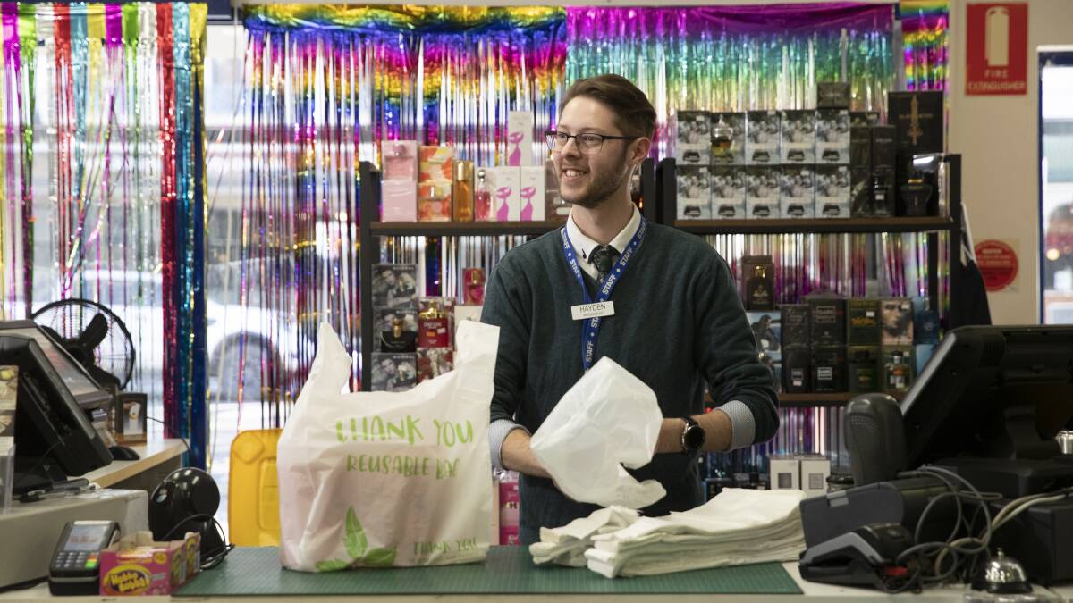 GEARING UP: Bargain Buys sales assistant Hayden Russell with some of the thicker 'reusable' plastic bags which the business has implemented ahead of the NSW government's ban on some single-use plastic bags. Picture: Madeline Begley
