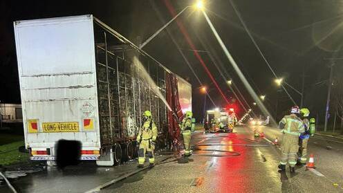 CHARRED: Fire and Rescue NSW crews extinguishing the blaze that engulfed a truck's trailer in East Wagga overnight. Picture: Fire and Rescue NSW