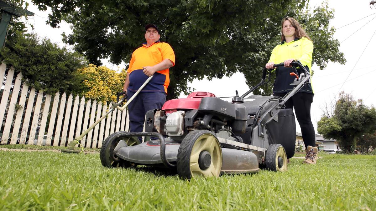 BUSY: Kurtis Goodsell and Kirsty Solly have been working seven days a week to manage Wagga's lawns over the past few weeks. Picture: Les Smith